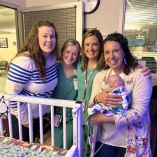 IMG_2514 (1) Mom and NICU staff smiling with baby.